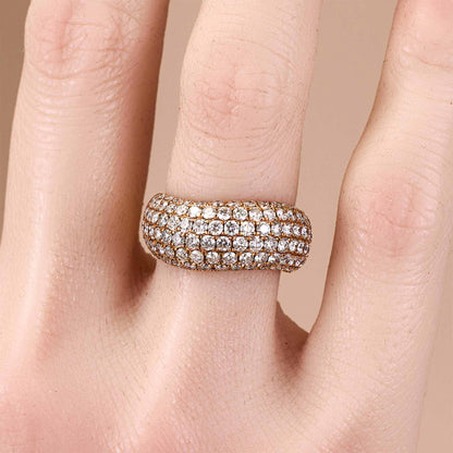 Rose gold ring with diamonds on a finger against a beige background from JewelryandStore